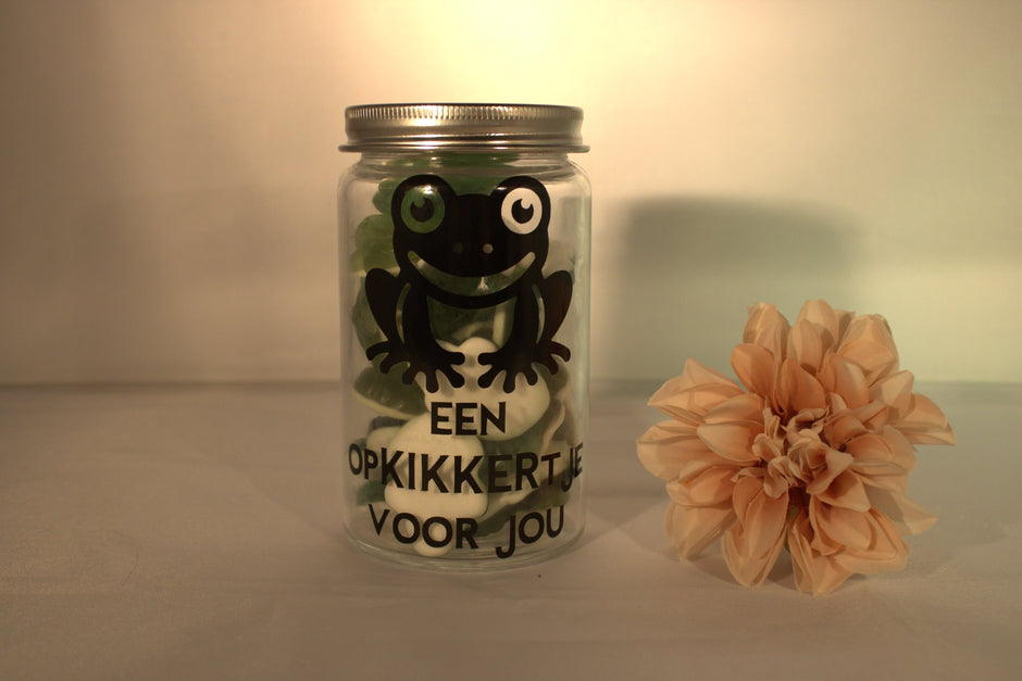 Glazen snoeppotje met kikker illustratie en tekst 'Een opkikkertje voor jou' gevuld met Haribo kikkers – leuk beterschap cadeau