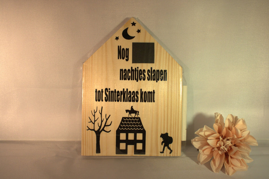 Houten sinterklaas aftelkalender in huisvorm 'Nog ... nachtjes slapen tot Sinterklaas komt' met Sint op dak, boom en Piet silhouet – feestelijke kinderdecoratie pakjesavond