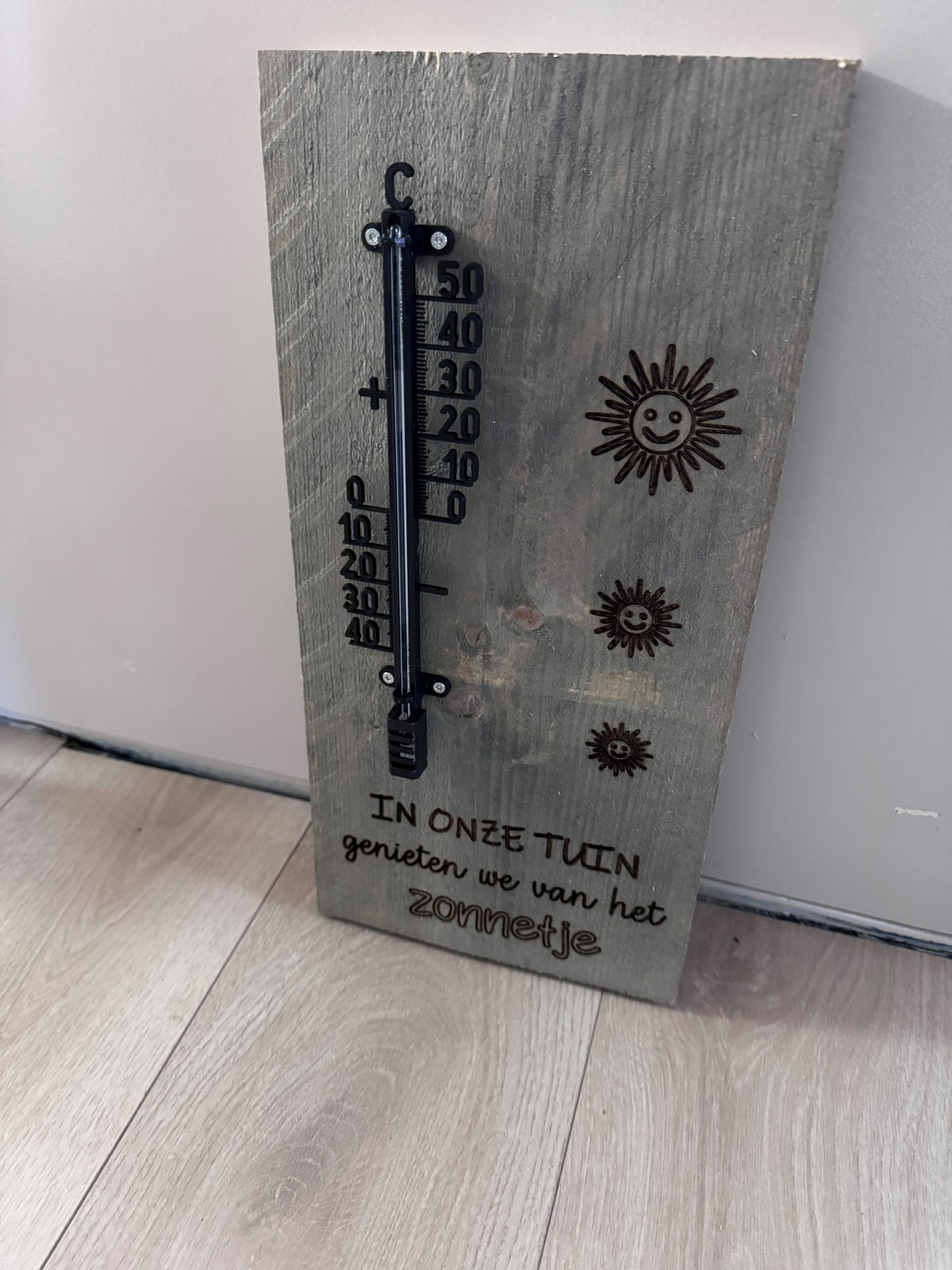 Houten tuinplank van steigerhout met thermometer en gelaserde tekst 'In onze tuin genieten we van het zonnetje' – 40x20 cm