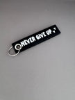 Zwarte viltsleutelhanger met witte tekst 'Never Give Up' – motiverend cadeau van Shop V-Ric
